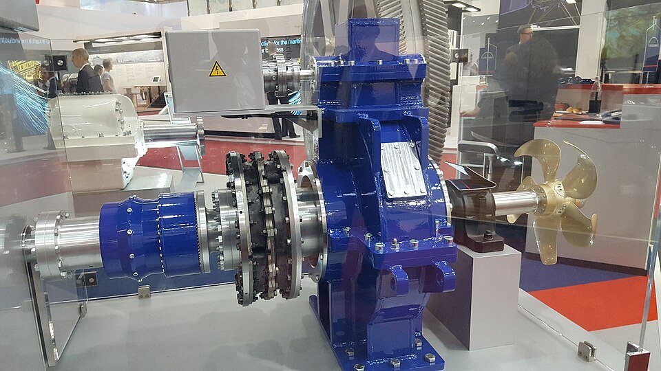 Industrial flexible coupling connecting shaft and gearbox in a protected machinery display.