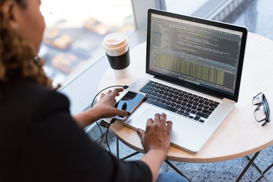 Black woman programming at a laptop, representing applied computing, AI and data-science study.
