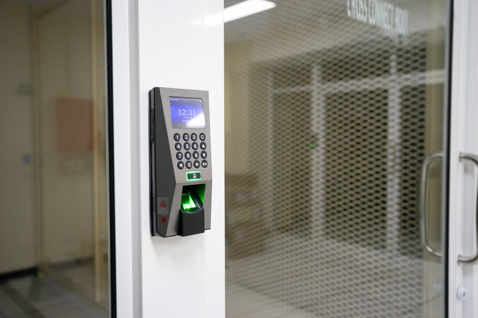An access-control keypad and fingerprint reader beside a secure door.