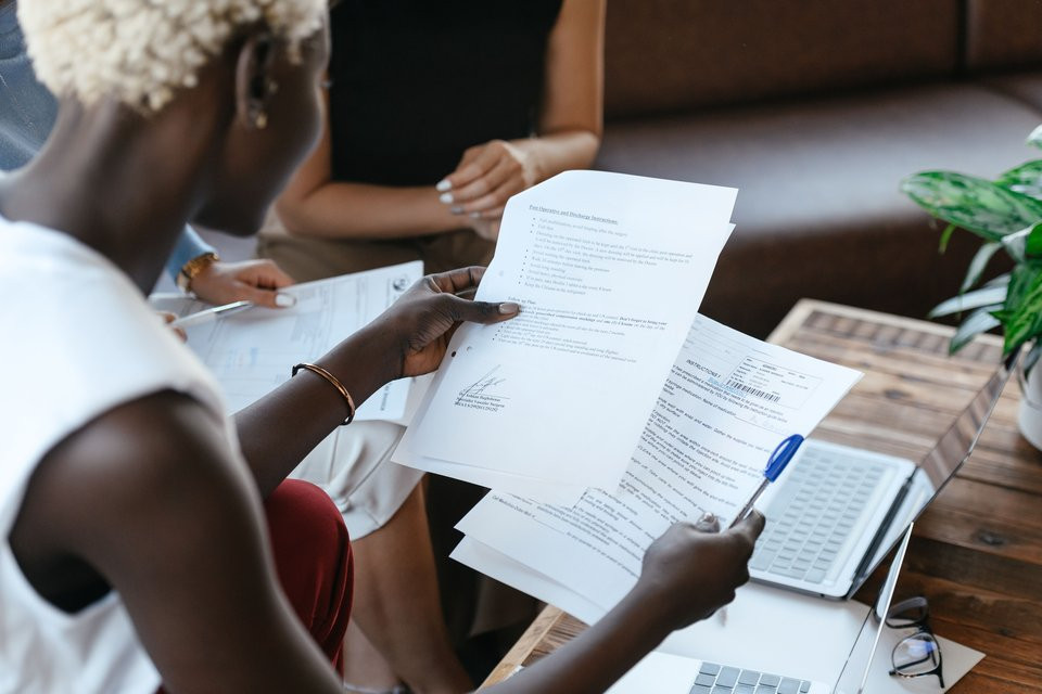 Colleagues comparing documents during a review meeting.