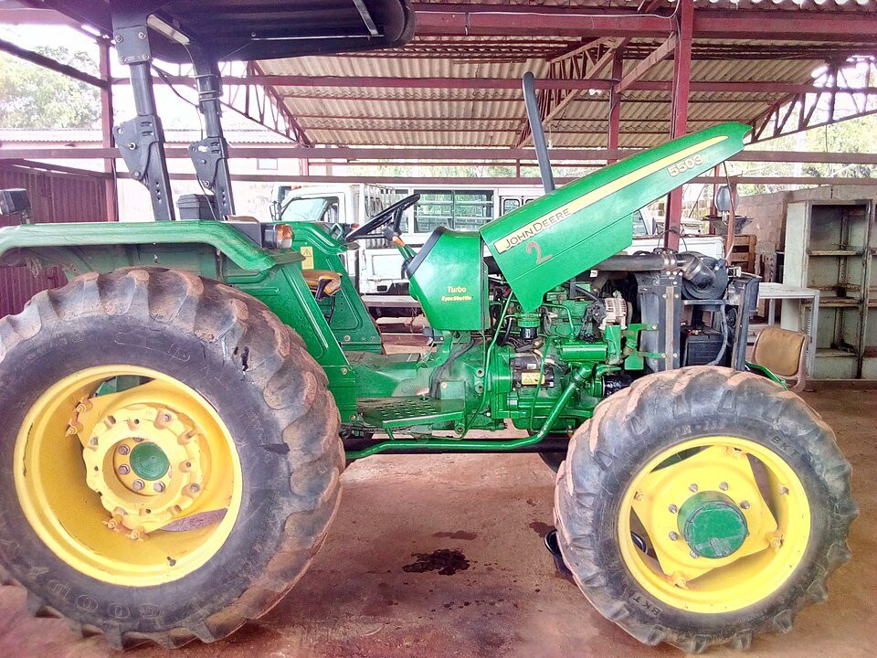 Tractor undergoing repair in a mechanical workshop.