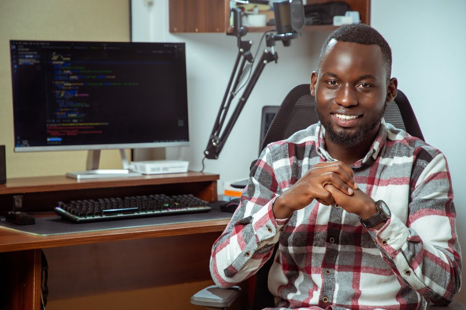Programmer at a desktop computer displaying source code.